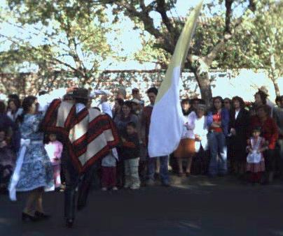 Two young people in traditional dress dancing the cueca, Chile's national dance, in celebration of the feast of the Virgen del Carmen.