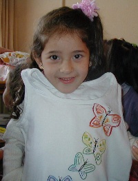 Daniela at her 6th birthday party, modeling the dress I embroidered for her.