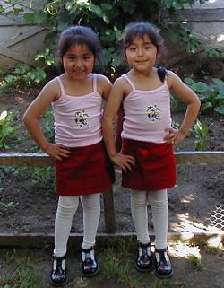 Twins modeling the skirts their mother learned to sew in the Fashion workshop.