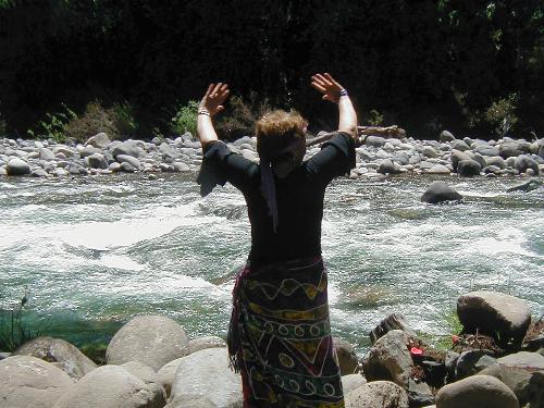 Nina dancing in front of the river in a ritual in memory of her son.