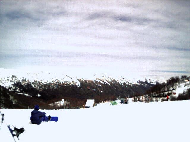 A skier looks out over the snow-capped mountains.