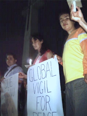Felipe holds up one end of his sign: 'Global Vigil for Peace.'