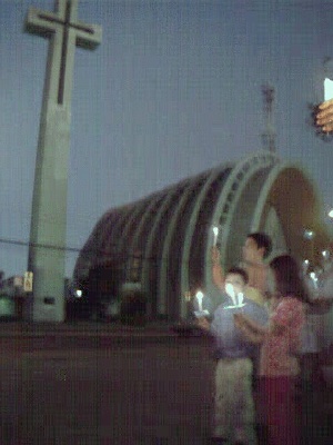Nicol�s, Mat�as and Daniela hold up their 'lights for peace' in front of Chill�n's landmark cathedral.