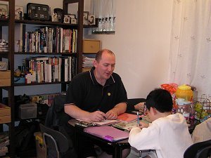Teaching English to a primary school student at his home.