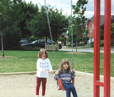 Emma pushing Maddie on the swing