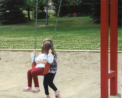 Maddie pushing Emma on the swing