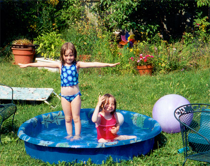 Maddie and Emma in the wading pool- dancing and playing air guitar