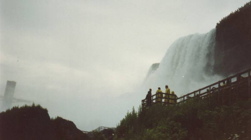 Here's you can see People in Raincoats and from a Distance Tiny People at the Top of the Falls