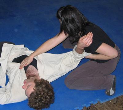 Deanne grapples with Ollie after throwing him to the ground.
