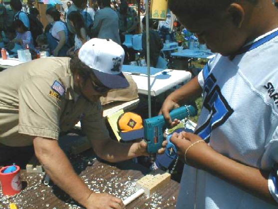 Drilling holes in the pvc pipe to construct a musical flute at Scout-o-Rama 2001 at Kennedy Park in Hayward