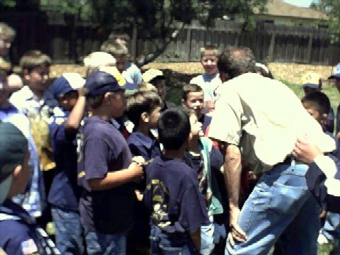 Cubmaster and Scouts plotting against adults in tug-o-war
