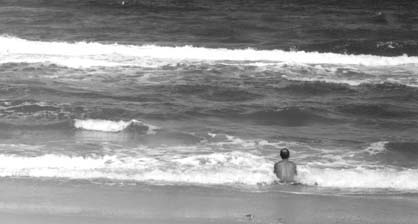 A man sits in the surf
