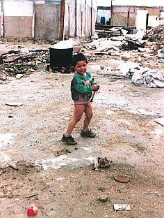 Half-naked child playing in the wet dirt road.