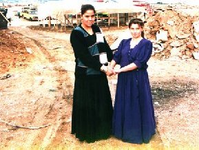Two young girls in their finest clothes pose for the photographer.