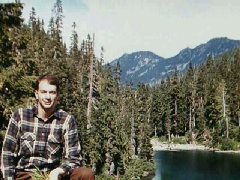 Phil kneeling by a mountain lake