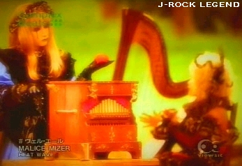 ...while Mana-sama turns a music-box, holding a tomato (!?), & Kozi-sama plays the harp