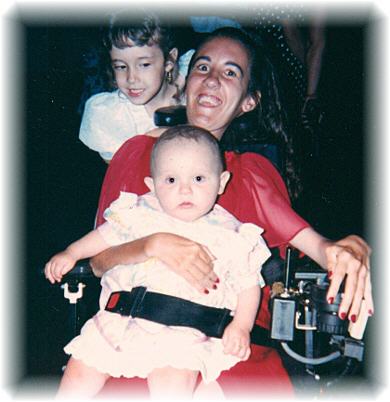 Danielle holding her cousin's baby, and her niece in back of her.