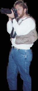 Mike taking a photo, wearing a photo vest and holding a camera