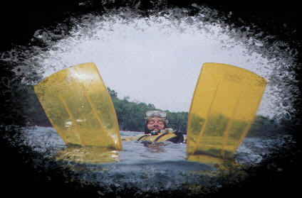 Picture of John in his scuba suit and his yellow fins sticking up in the air.