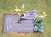 Not too long ago, some friends of Peter also stopped by.  The wind had blown over the flowers.  I carefully brushed the soil from the headstone and placed the flowers upright.  The potted daffodils appear very recent.  This photo was taken on 03-26-2004.