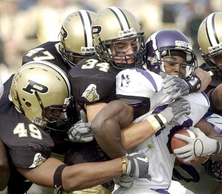 Northwestern's Terrell Jordan is tackled by Purdue's Anthony Spencer (49), Landon Johnson (47) and Niko Koutouvides (34) during the second quarter.