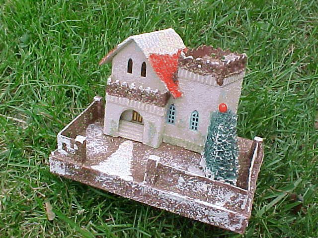 This is a semi-giant-full coco: 8 1/4 X 5 1/2" base. Everything about this one says pre-war. The style, the windows, the wooden fenceposts. Except it bothers me. It's just too clean, and although it doesn't show well in the picture - gold glitter among the coconut where it is brown.I had thought that only to appear in the '50's, but as usual .. I could be wrong! 