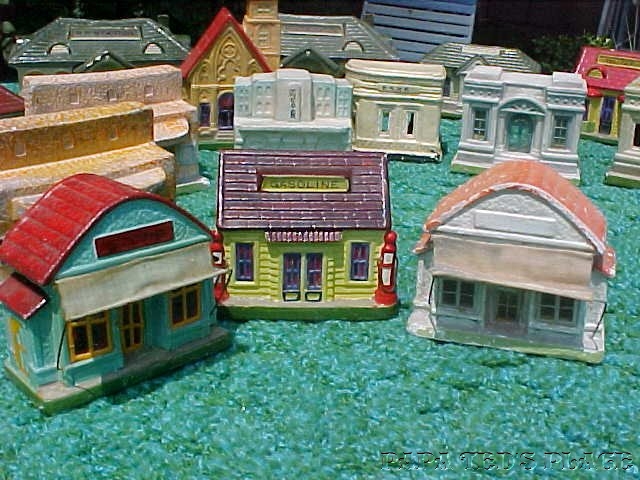 Two examples of the little "store." Many of the buildings are found in differing paint schemes. The stores with awnings aren't as common as without. They were made both ways and awnings are usually missing anyway. Quite fragile! The "gas station" has strange little moveable wire attachments, meant to be gas hoses, I imagine. 