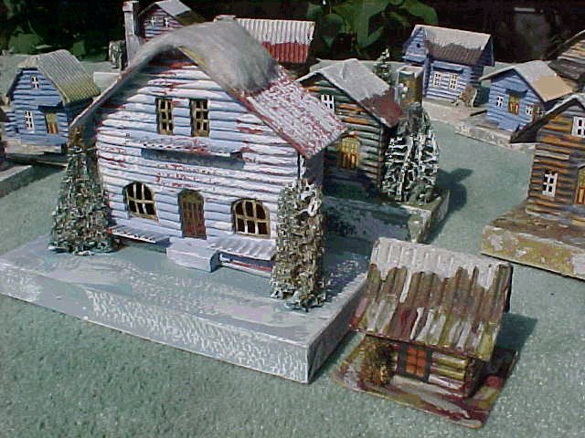 There aren't that many different styles of Loggies but they came in different finshing schemes and a wide range of sizes. Many sets included 1 LOGGIE in with 7 others of the "in town"style. Above is shown a large Cotton-Topperalong side the "Little Guy" again. The clear cellophane door is a possible indicator that it is post war, but that's not entirely reliable, as cellophane doors do appear in late '30's pieces. The more intricate printing pattern is probably indicative of late prewar. I have seen at least one LOGGIE with a base 11 3/4" X 9 1/2" that would fully cover a standard sheet of typing paper and more.(The prewar GIANT class.) But it was exactly the same style and had no more detail than the medium size version. 