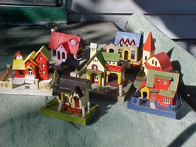 This set belonged to a family named Bair. They are without doubt the among most elaborately detailed and extraordinarily structured Christmas Houses ever made, and these are the only I have ever seen. They are definely LACQUERS: - glossy all over, except for sandy round fences posts on some of them. 