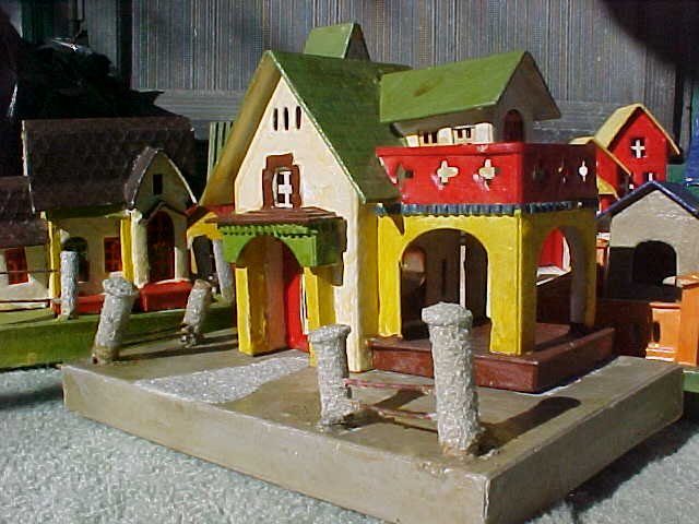 Note the elborate porticoed veranda or car-port. Several of the set have these. And the windows are most unusual - with clear cellophane on inner portals to give subtle lighting effects and standard Christmas house doors found in others, along with these odd, boldly barred large windows - which I am still trying to make up my mind about. Original or homemade? The jury is still out on that one ...... 