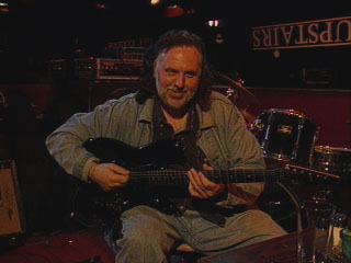 Jimmy strums his guitar.