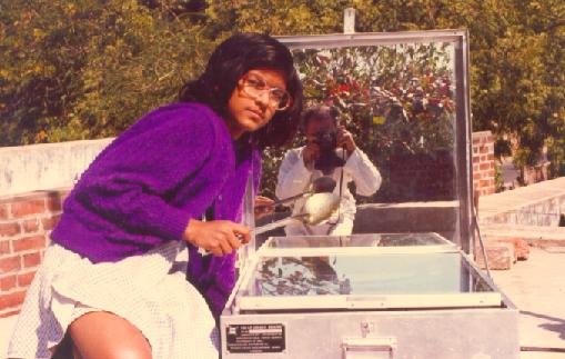 Sulagna stirs the chicken in solar cooker every hour to monitor