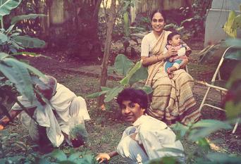 The leafy banana trees decorate the garden well, Kanya helps in shifting and watering