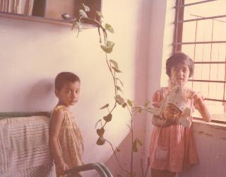 Sulagna holds mask of Devi Durga near money plant in sunlit room