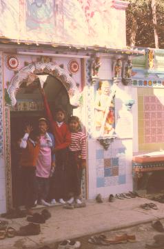 Children enthusiastically try to ring the temple bell
