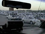Not a bad place to park your car!  Now if I can find you in that crowd of parked cars, we'll both have a great day!:-)  This was shot from my office... the drivers' seat of my shuttle van, looking out the center of the windshield from the seat, at all the parked cars before me.  The radio, as you see, is on the dash, in the foreground