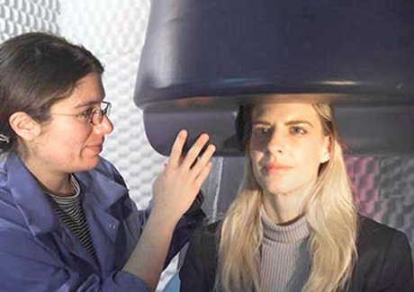 Una especialista ajusta el casco del magnetoencefal�grafo a una paciente