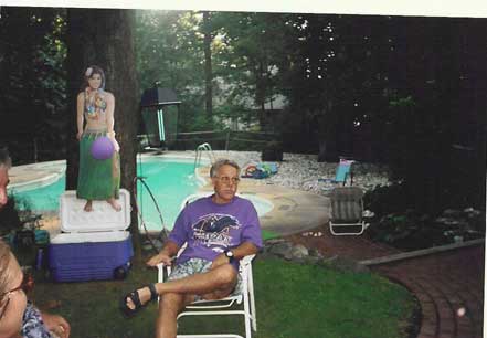 Stu Brandt relaxes by the pool as the hula girl looks on.