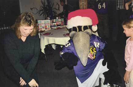 Kim McKee welcomes Ravens mascot Poe to the party.