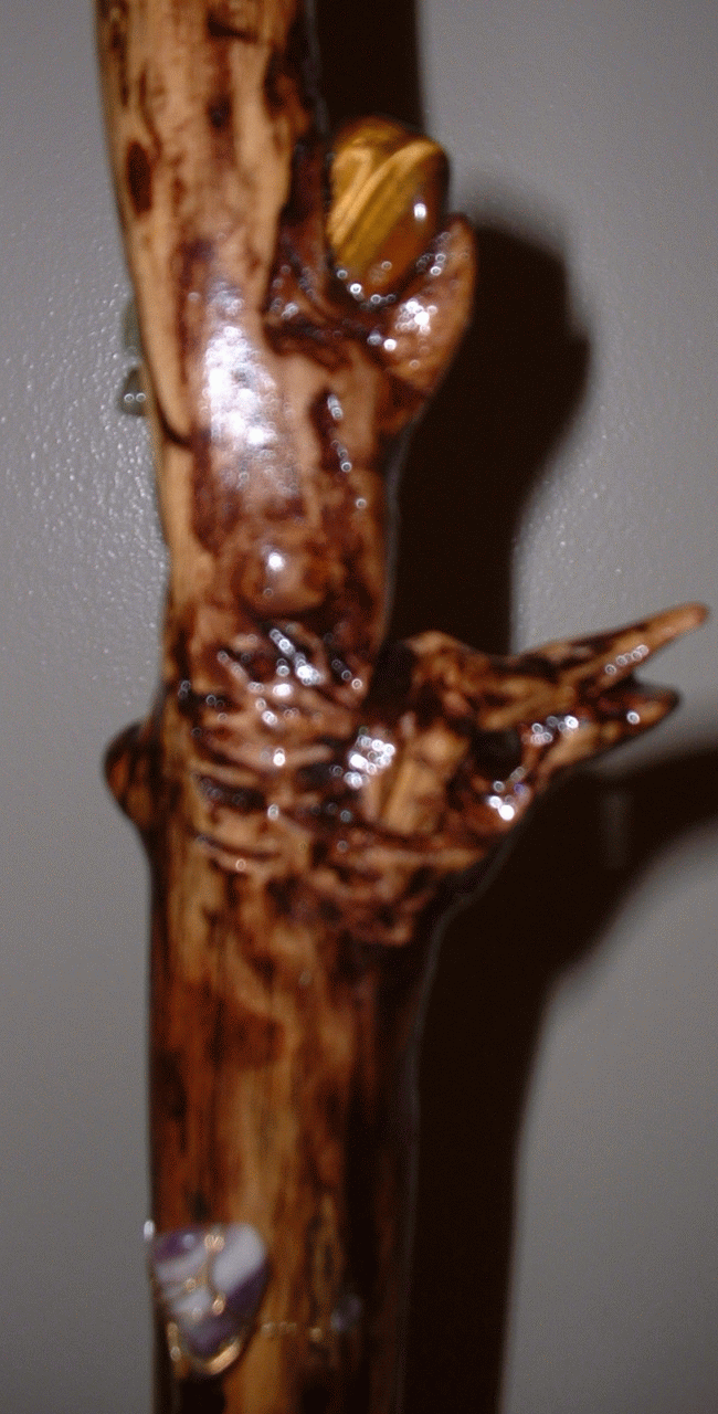 up close detail of carving on a staff made of oak,&nbsp; stone above it is tiger's eye