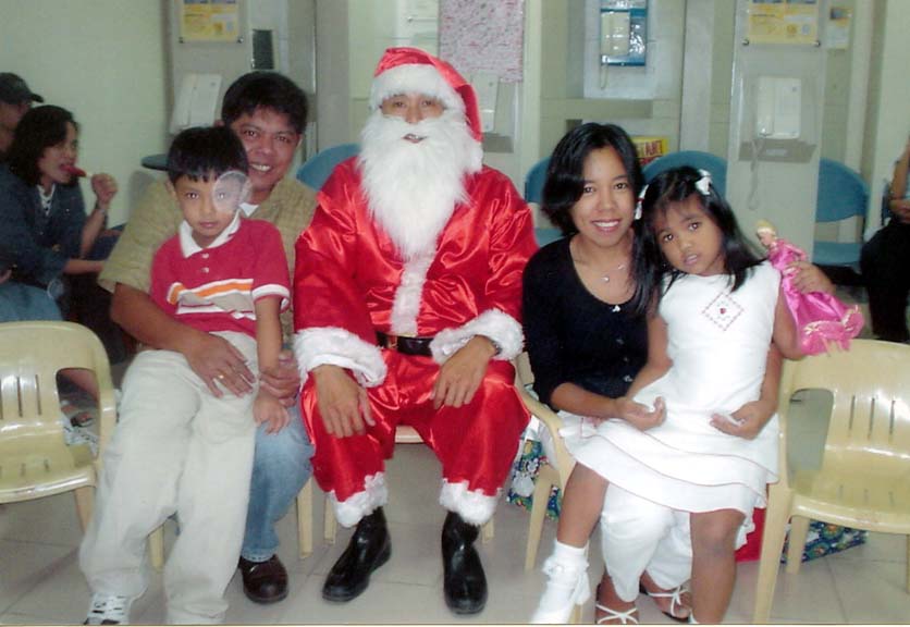 Our Family picture during our Office Christmas Party 2002 with a undernourished Santa