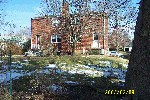 Back yard from the property line in the alley behind house.