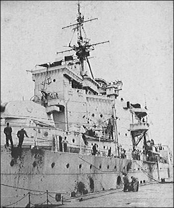 H.M.S London alongside at Shanghai. Notice the damage to her hull and superstructure.