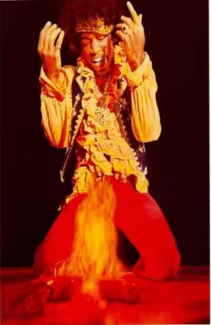 Hendrix kneeling over his burning guitar at The Monterey Pop Festival.