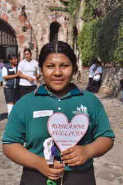 Guadalupe holds a heart with my name on it and a paper flower she made