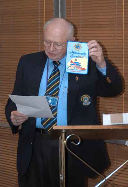 Lion Secretary Wil Hufton holds up the Lions International patch the club received for the sucesses of the membership drive.