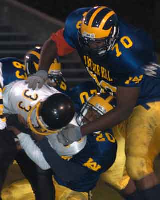 Arthur Hill's defense swarms the Saginaw High running back.