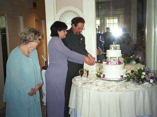 Dave Feder and Liz Luttrell cut the cake while Queenie Feder watches