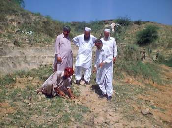A Local planting saplings under the watchful eyes of Dr A R Baig