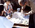 The finished rice cakes, mochi, are molded into round balls for the offering